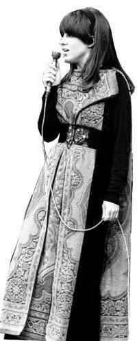 an old photo of a woman with a microphone in her hand and wearing a long dress