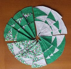 a green and white christmas tree ornament sitting on top of a wooden table