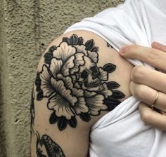 a woman's arm with a flower and snake tattoo on the left side of her arm