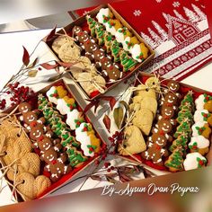 several decorated cookies in boxes on top of a table next to a red box with white and green decorations