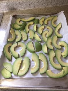 an uncooked avocado cut in half on a baking sheet