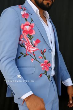 a man wearing a blue suit with pink flowers on it