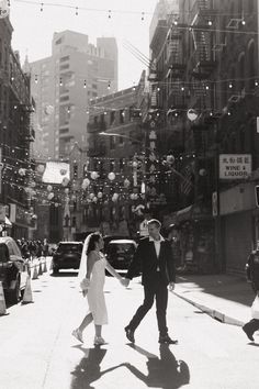 a bride and groom walking down the street in new york city