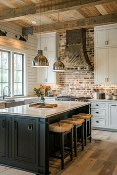 a kitchen with white cabinets and black island in the center, surrounded by stools