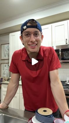 a man standing in front of a kitchen counter with a cake on top of it