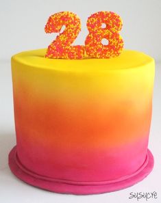 there is a yellow and pink cake with the number 28 on it