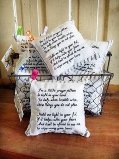 some pillows that are on top of a wooden table and one is in a basket