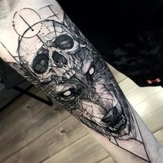 a man's arm with a tattoo on it that has a wolf in the middle