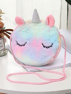 How charming is this fuzzy unicorn circle bag? Trendy and cute, this accessory has a soft color mix and pretty details that are sure to make her outfits look lively and magical! Spacious interior fits her essentials, while its zippered closure makes sure her treasures are safe and secure! Can be used for school, casual outings, vacations, trips abroad, or everyday life on the go Pastel-colored unicorn handbag with crossbody strap Imported: This item ships from our overseas fulfillment center. On Cute Messenger Bags, Trips Abroad, Colorful Unicorn, Unicorn Bag, Her Outfits, Circle Bag, Disney Handbags, Kids' Bag, Rainbow Light