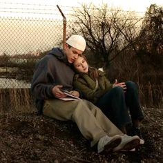 a man sitting next to a woman on the ground