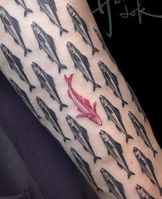 a person with a red fish tattoo on their arm