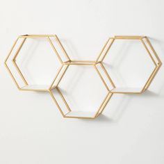 three hexagonal shelves are hanging on the wall