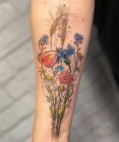 a woman's leg with flowers and butterflies on it