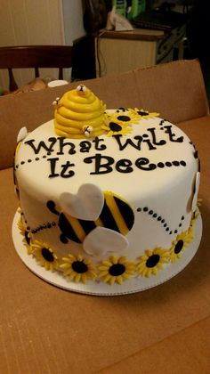 a birthday cake decorated with bees and honeycombs is on a table in front of a cardboard box