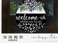 a welcome sign hanging from the side of a door with black and white designs on it