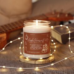 a candle sitting on top of a table next to a string of lights and a guitar