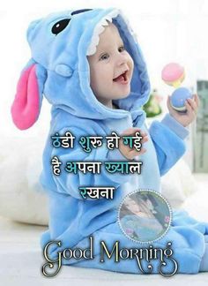 a baby in a blue elephant costume playing with an egg on the ground and saying good morning