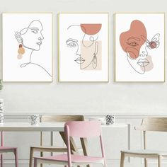 three framed art prints on the wall above a dining room table with two chairs and a pink chair