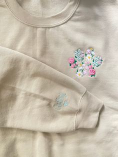 an embroidered t - shirt with flowers on it