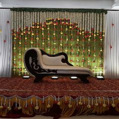 a bed sitting in front of a window with curtains on the side and lights behind it