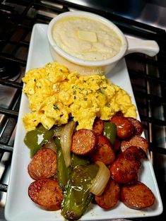 a white plate topped with breakfast foods next to a bowl of soup and sauce on the side