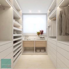 a walk in closet with white cabinets and drawers