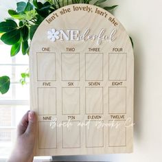 a wooden calendar hanging on a wall next to a potted plant