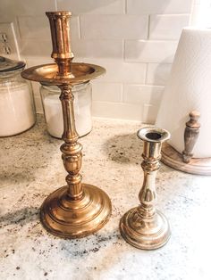 two candles are sitting on a marble counter top