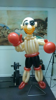 an inflatable clown with boxing gloves on stands next to a barbell set