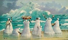 a group of women standing on top of a beach next to the ocean holding flowers