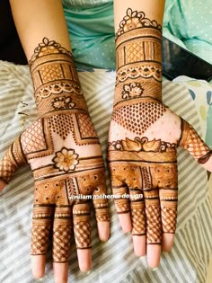 two hands with henna designs on them