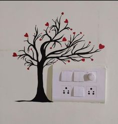 an electrical outlet with a tree painted on the wall and hearts falling out of it