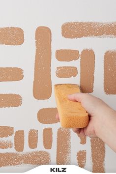 someone is painting the wall with brown paint