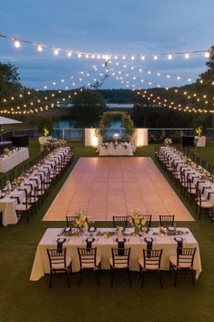 an outdoor wedding reception setup with lights strung over the dance floor and tables set up for dinner