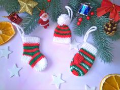 two knitted christmas stocking ornaments next to an orange slice