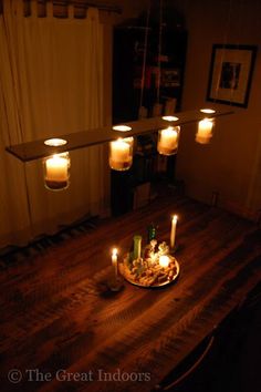 candles are lit on a wooden table in the dark