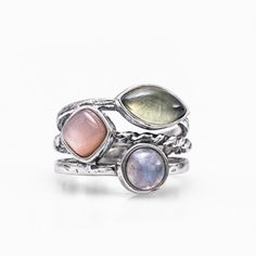 A shining stack of high-quality 925 sterling silver in tapering multi-textured bands sets with three unique multi colored gemstones in this celestial design. A round 1.1 ct. cabochon of rainbow moonstone radiates next to a 1 ct. cushion-cut pink moonstone, which glimmers next to a 1.3 ct. marquise-cut cabochon of prehnite. DETAILS: * Metal: Sterling silver * Stones: ‣ Rainbow moonstone round-cab 1.1 ct. ‣ Cushion pink moonstone 1 ct. ‣ Prehnite marquise-cab 1.3 ct. * Available sizes: 5-10 * Shap Celestial Design, Pink Moonstone, Colored Gemstones, Rainbow Moonstone Ring, Gem Ring, Purple Band, Elegant Ring, Multi Stone Ring, Moonstone Ring