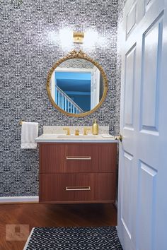 a bathroom with a sink, mirror and rug on the floor in front of it