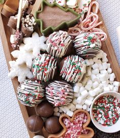 a wooden tray filled with lots of different types of candy and cookies on top of it