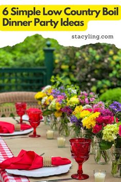 an outdoor table set with red and white napkins, vases filled with flowers and candles