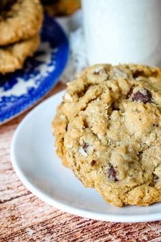 chocolate chip cookies on a plate next to a cup of coffee and a glass of milk