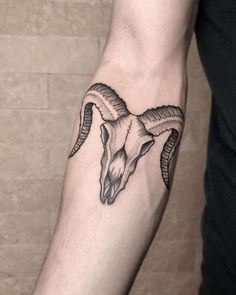 a goat skull tattoo on the arm