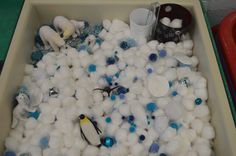 a bath tub filled with lots of white and blue bubbles next to two plastic cups