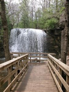 a wooden bridge leading to a waterfall