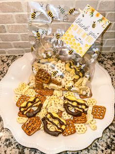 a white plate topped with cookies and pretzels next to a bag of honeybees