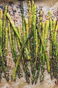 cooked asparagus on a baking sheet with seasoning