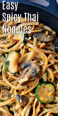 a skillet filled with noodles, mushrooms and zucchini in sauce that says easy spicy thai noodles