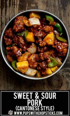 a bowl filled with meat and vegetables on top of a wooden table next to a sign that says sweet & sour pork