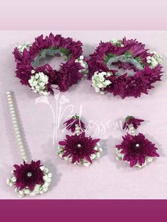 purple and white flowers are on display with pearls in the middle, along with other accessories