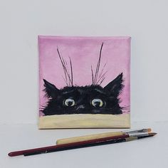 a painting of a black cat on a pink background next to a pencil and eraser